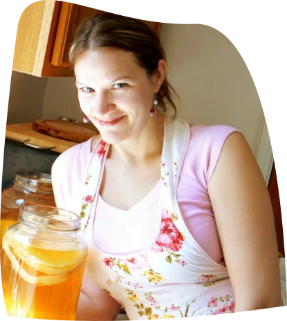 A photo of Hannah Crum next to a jar of brewing kombucha.